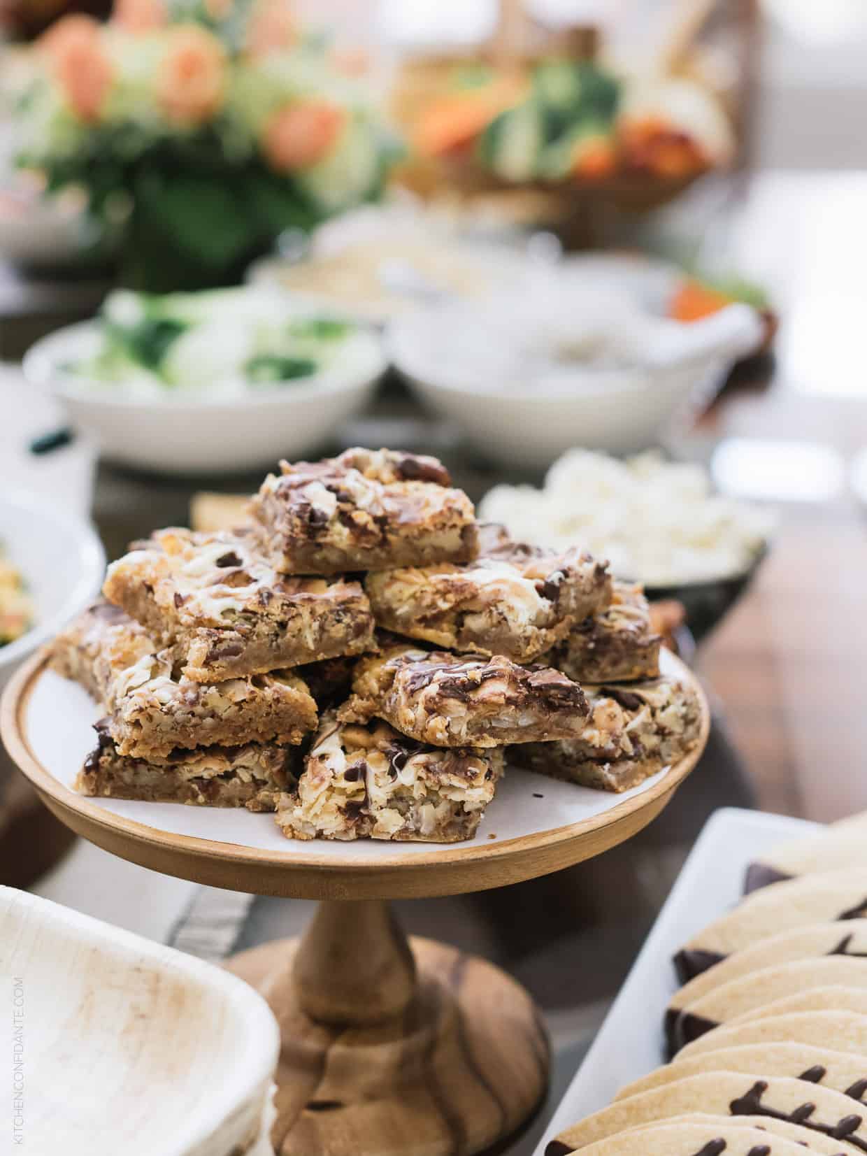 7 Layer Bars cut into rectangles and stacked on a cake plate.