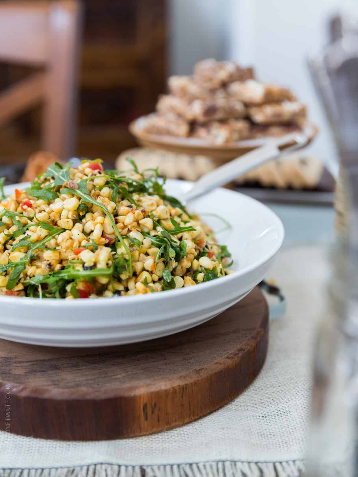 A white bowl full of a corn salad.