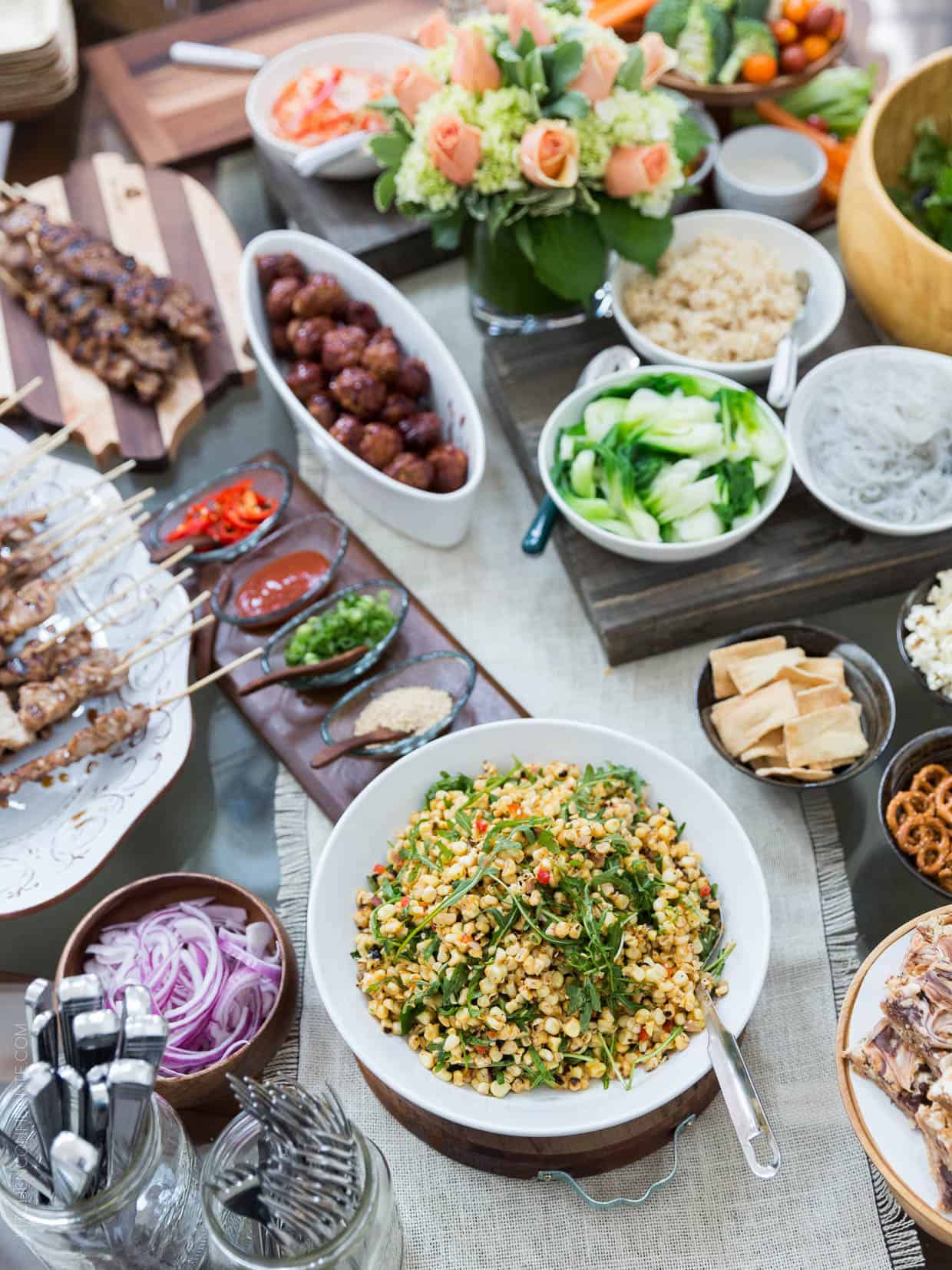 A table full of serving platters piled high with food and toppings for a big game party.
