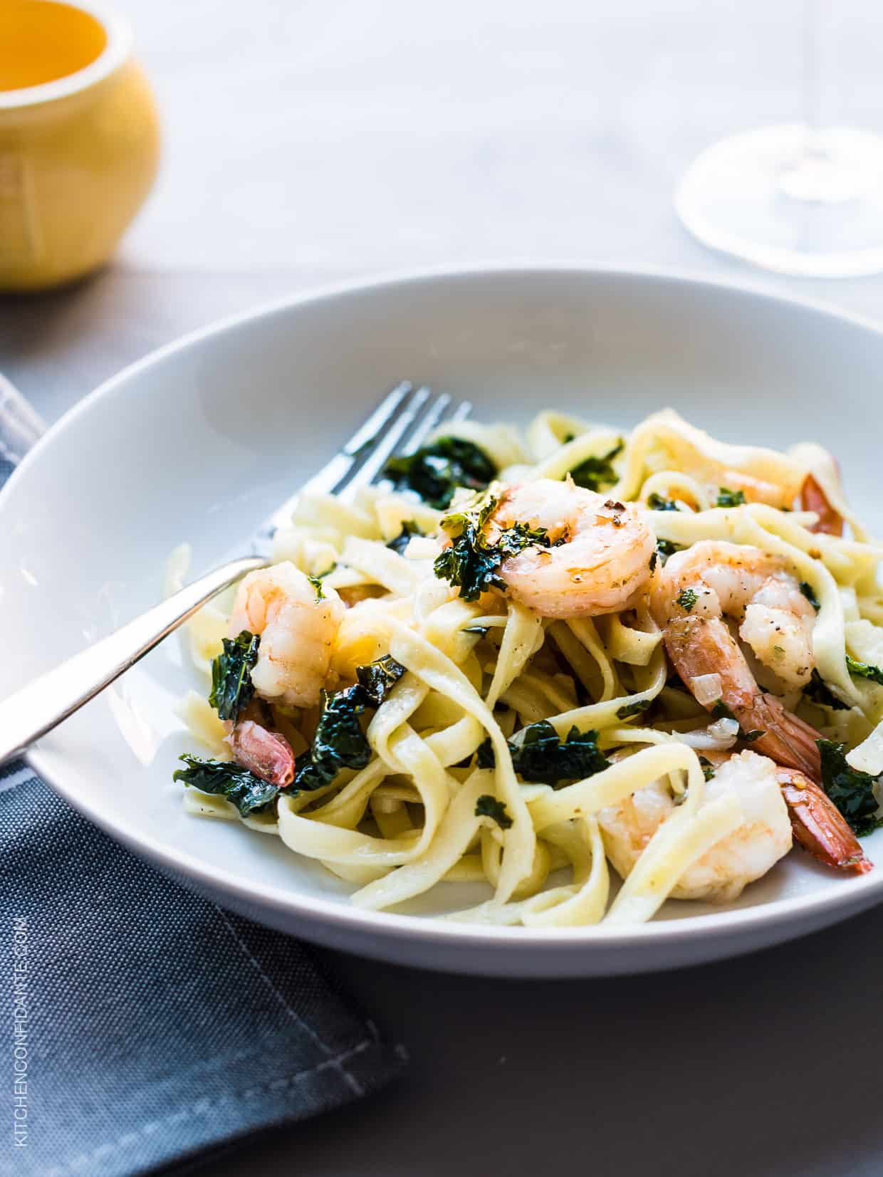 Freshly cooked linguine, leafy kale, and shrimp twirl together on a dinner plate to create Kale and Shrimp Scampi. 
