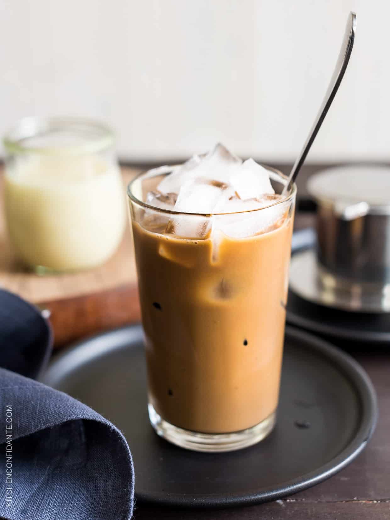 A tall glass of Vietnamese Iced Coffee (Ca Phe Sua Da) with a spoon to stir. 