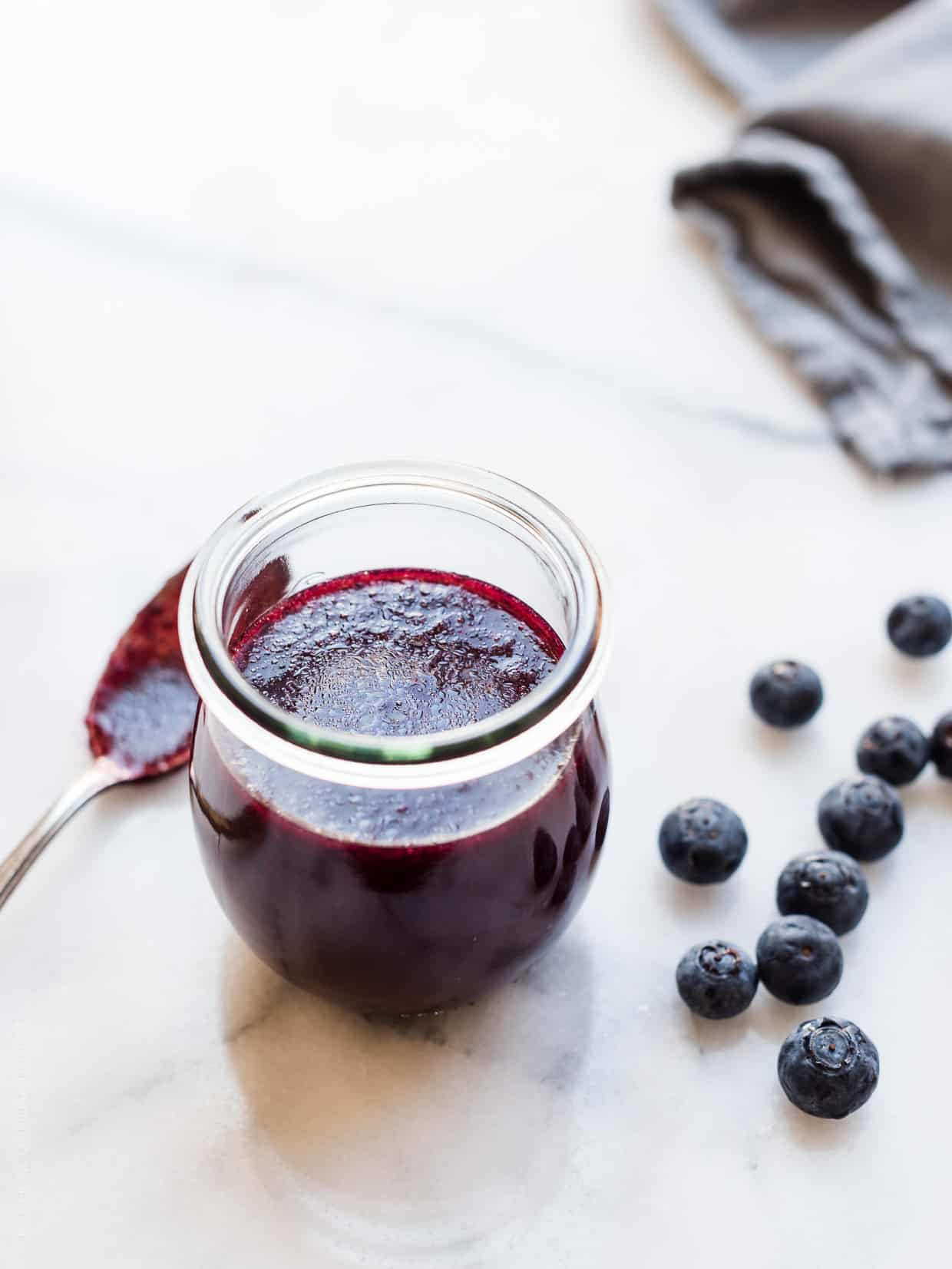 Glass jar filled with fresh homemade blueberry salad dressing.