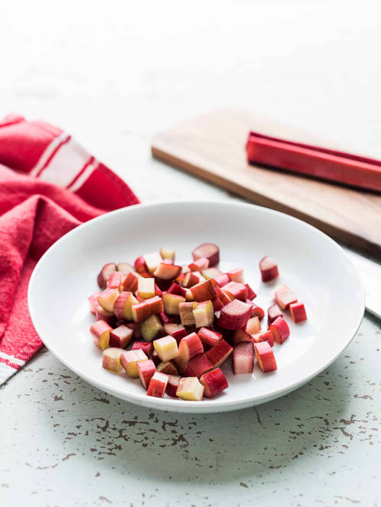 White plate filled with diced rhubarb cubes.