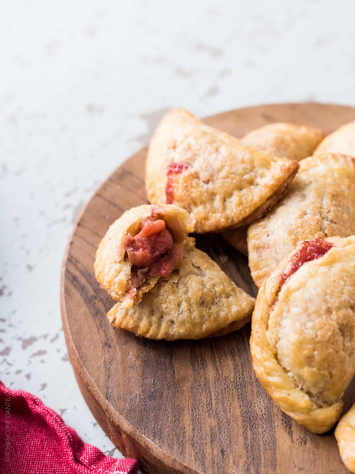 Rhubarb empanadas on a wooden serving board.