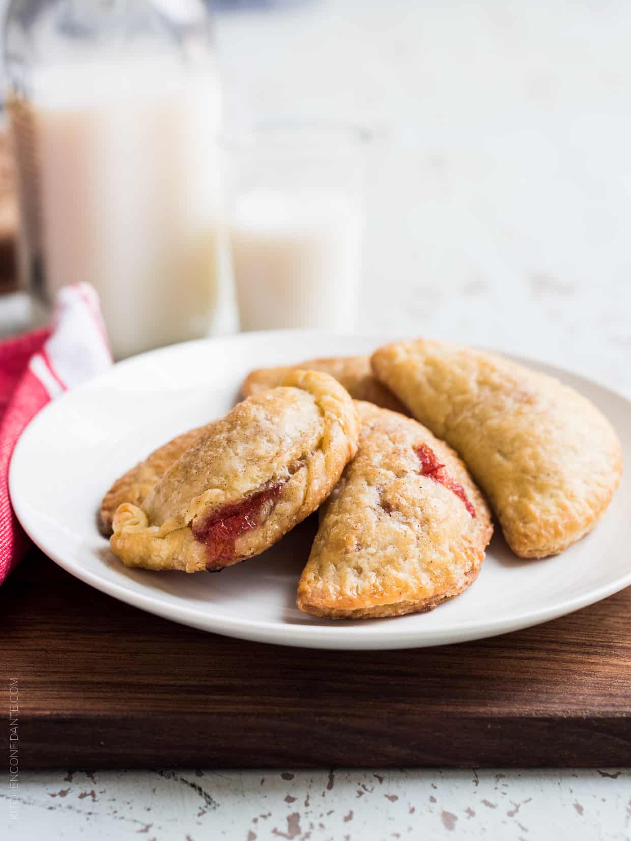 Four rhubarb empanadas on a white plate.