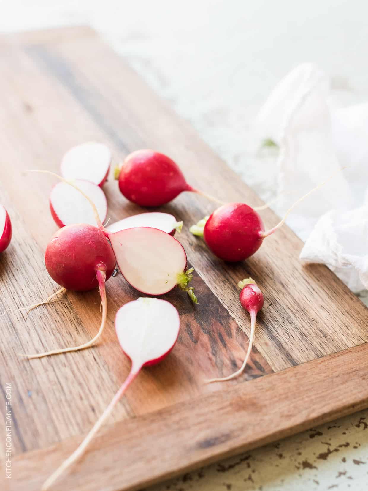 Halved radishes on a wooden surface.