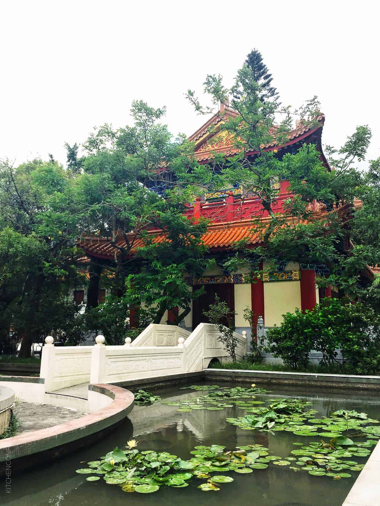 An image of a traditional hong kong building, with a moat filled with lilly pads.