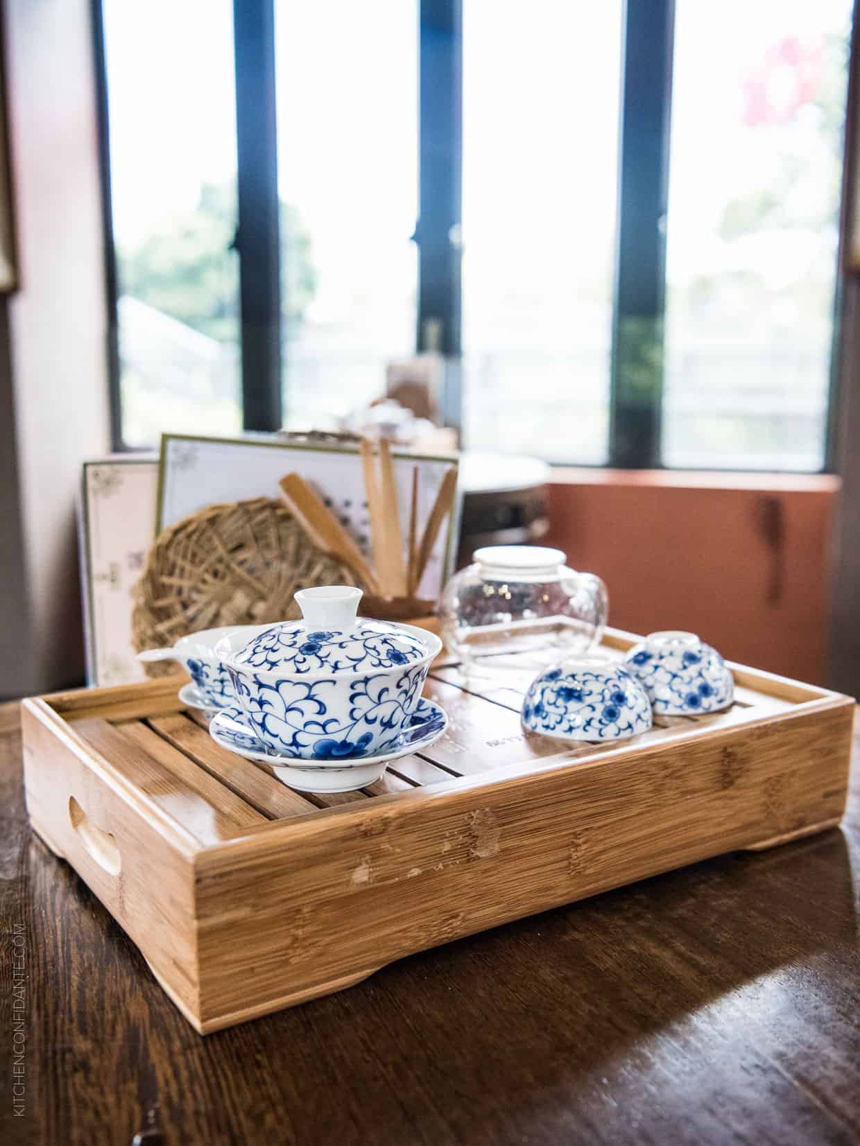 Traditional blue and white tea service laid out on a bamboo tray.