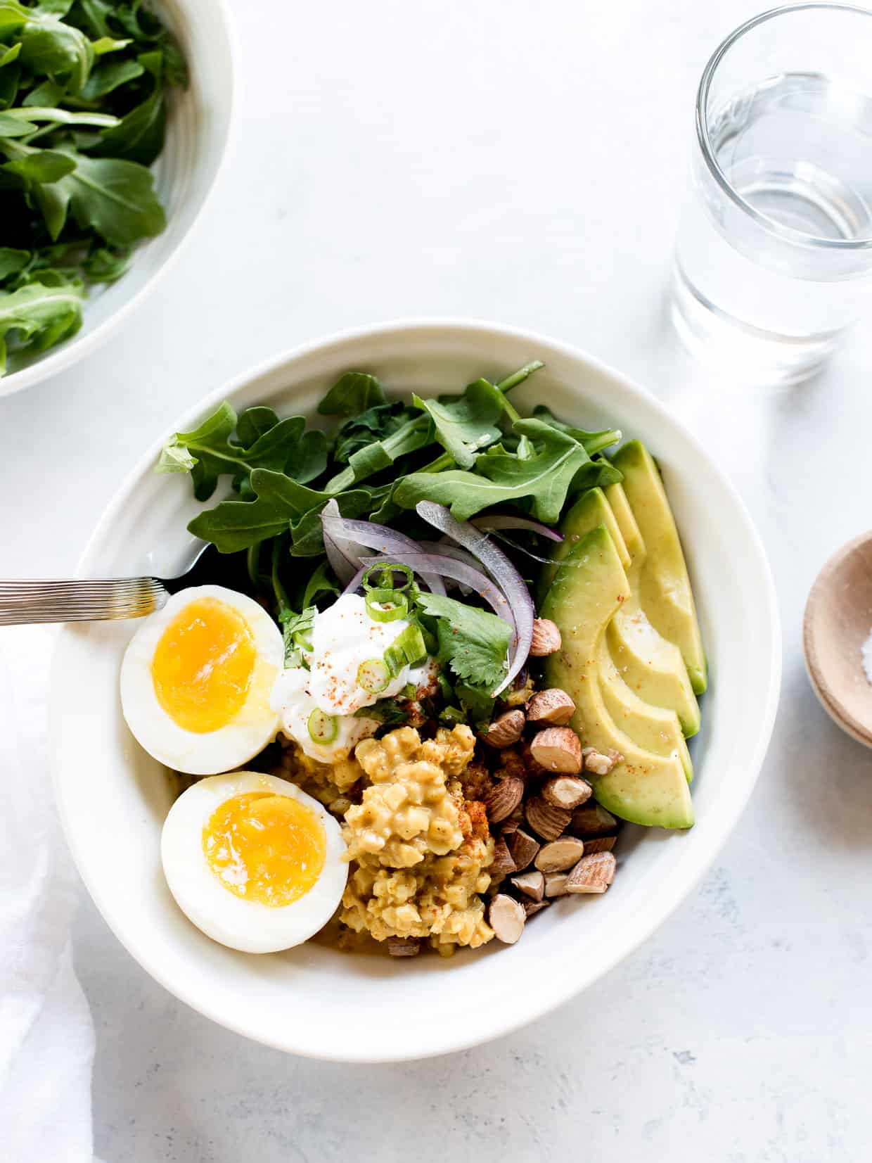 Coconut Curry Cauliflower Rice Bowls topped with eggs, almonds and avocado slices.