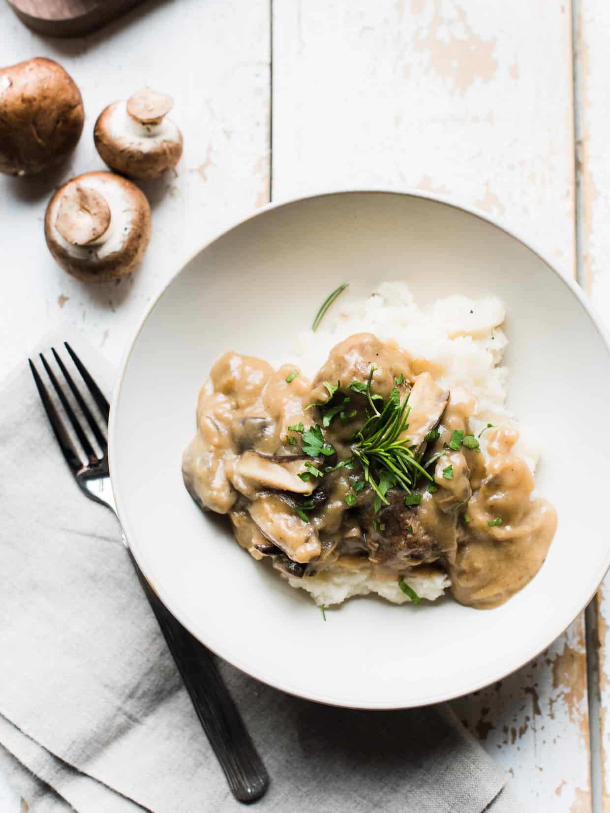 Swiss Veal and Wild Mushroom Stew garnished with fresh herbs in a bowl.