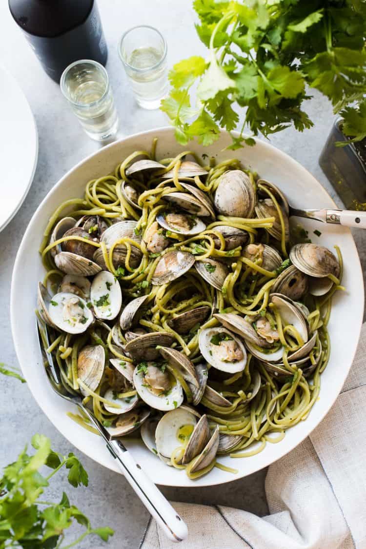 Spinach Linguine with Clams in Sake Red Chili Sauce in a white bowl.