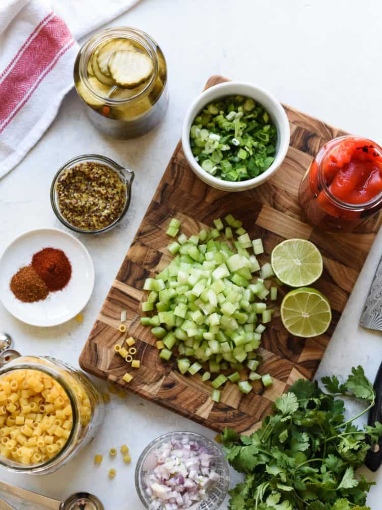 Chopped celery on a cutting board surrounded by other ingredients for Fireworks Pasta Salad