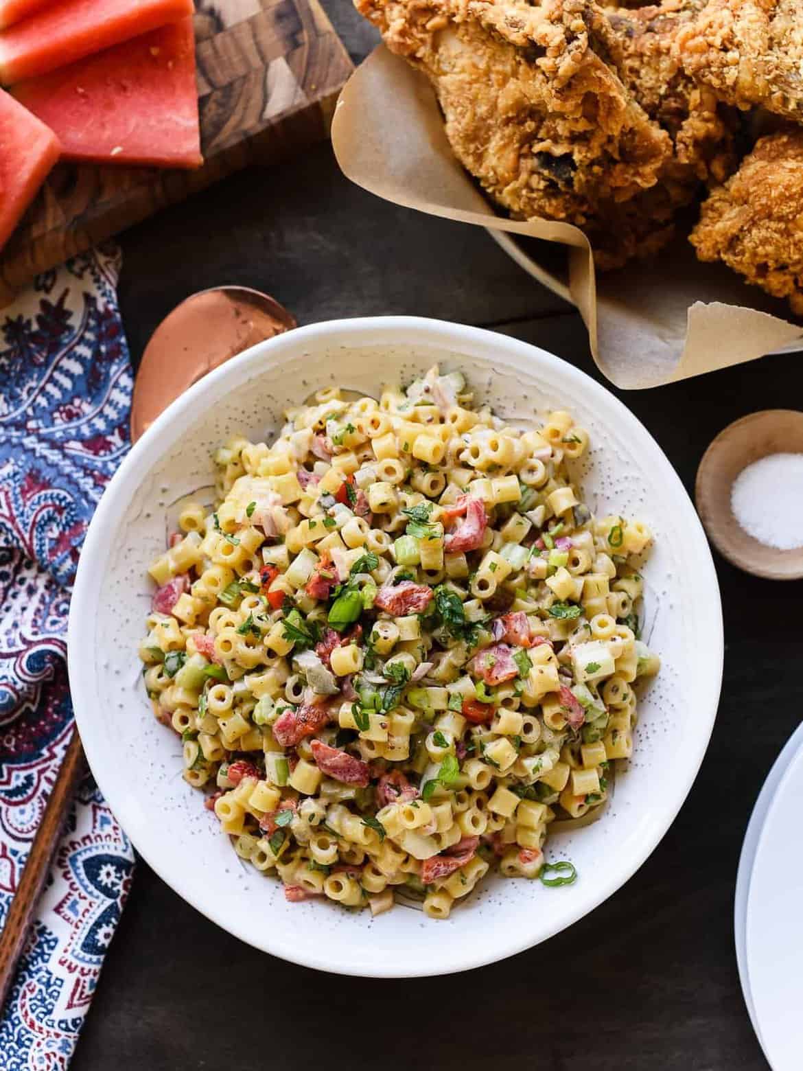 Fireworks Pasta Salad in a white bowl on a picnic table