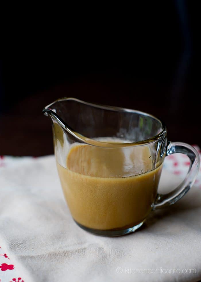 A small glass pitcher filled with homemade butterscotch sauce.
