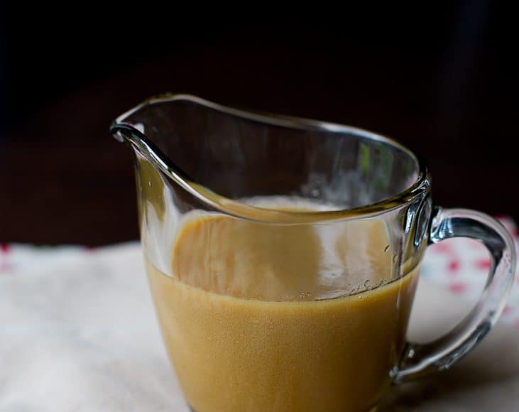 A small glass pitcher filled with homemade butterscotch sauce.