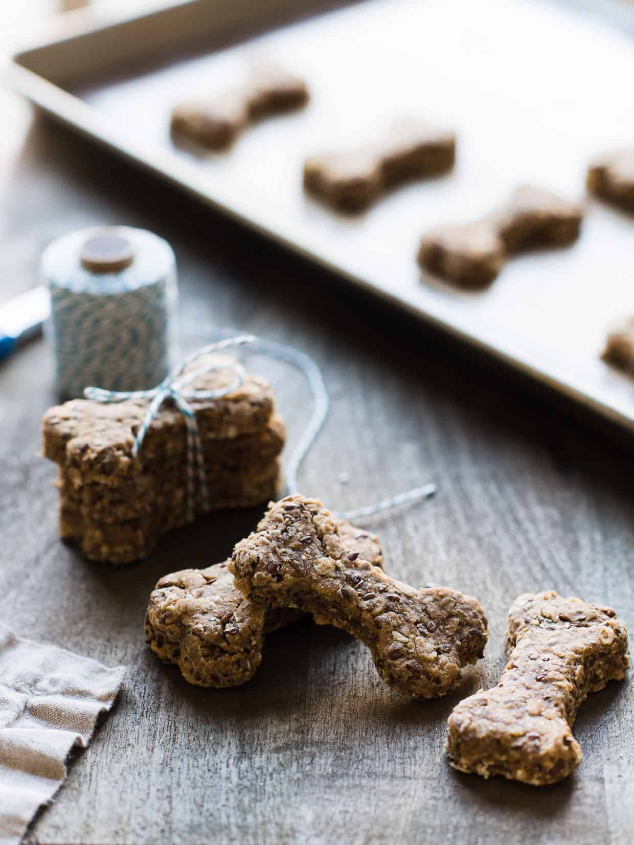 Homemade dog biscuits made with peanut butter, flaxseed and whole wheat flour on a baking sheet.