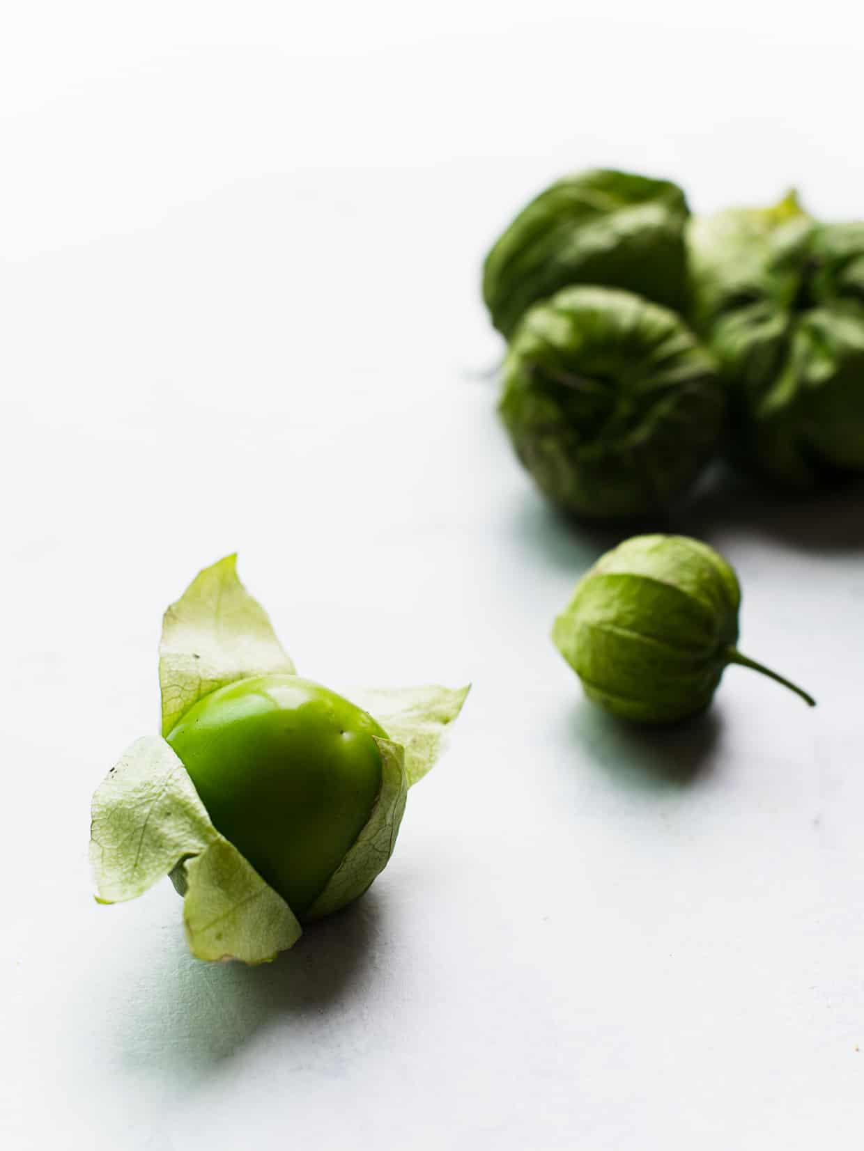 Small green fruit sometimes referred to as a "husk tomato" being prepared.