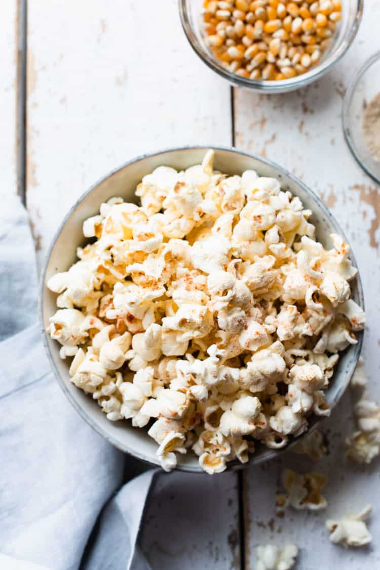 Sweet and spicy wasabi popcorn in a bowl on a white table.