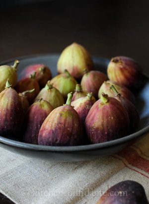 A dark bowl filled with fresh figs.