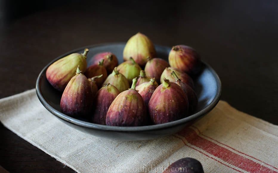 A dark bowl filled with fresh figs.