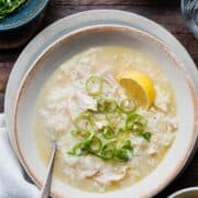 bowl of Arroz Caldo, Filipino chicken and rice soup, topped with green onion and garlic.