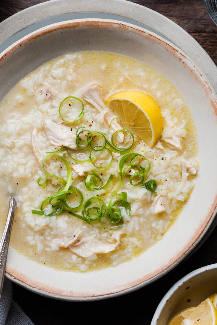 Arroz caldo with garnishes on wood table.