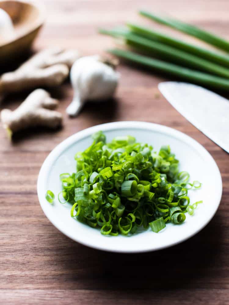 Sliced scallions in a white bowl.