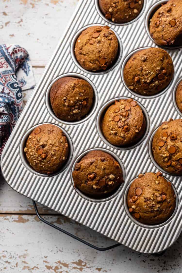 Cinnamon Chip and Walnut Pumpkin Muffins in a muffin pan.