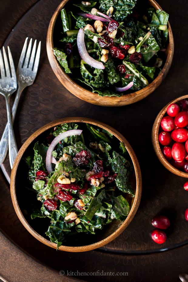 Cranberry Walnut Kale Salad in wooden bowls with fresh cranberries
