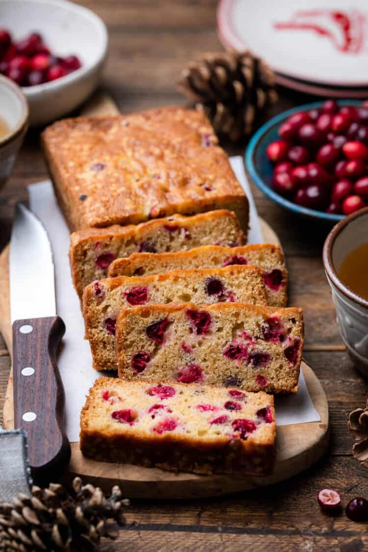 Fresh Cranberry Tea Cake slices on a cutting board on a wooden table.
