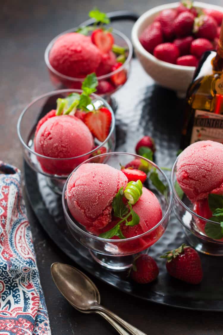 Strawberry Cointreau Sorbet in a serving dish garnished with lime zest and mint.