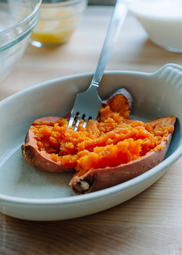 Sweet potato being prepared with a fork to use in a recipe for Sweet Potato Pancakes.