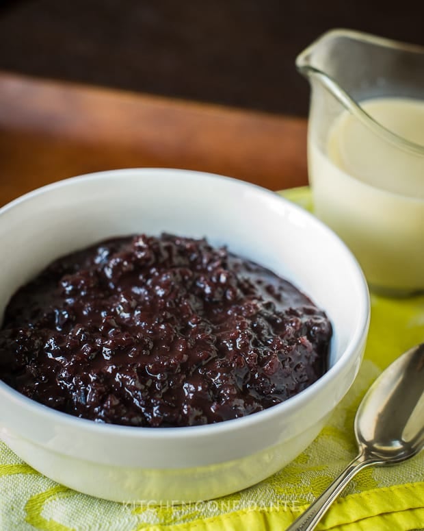 A white bowl full of Champorado: Filipino Chocolate Rice Pudding sits on a yellow napkin.