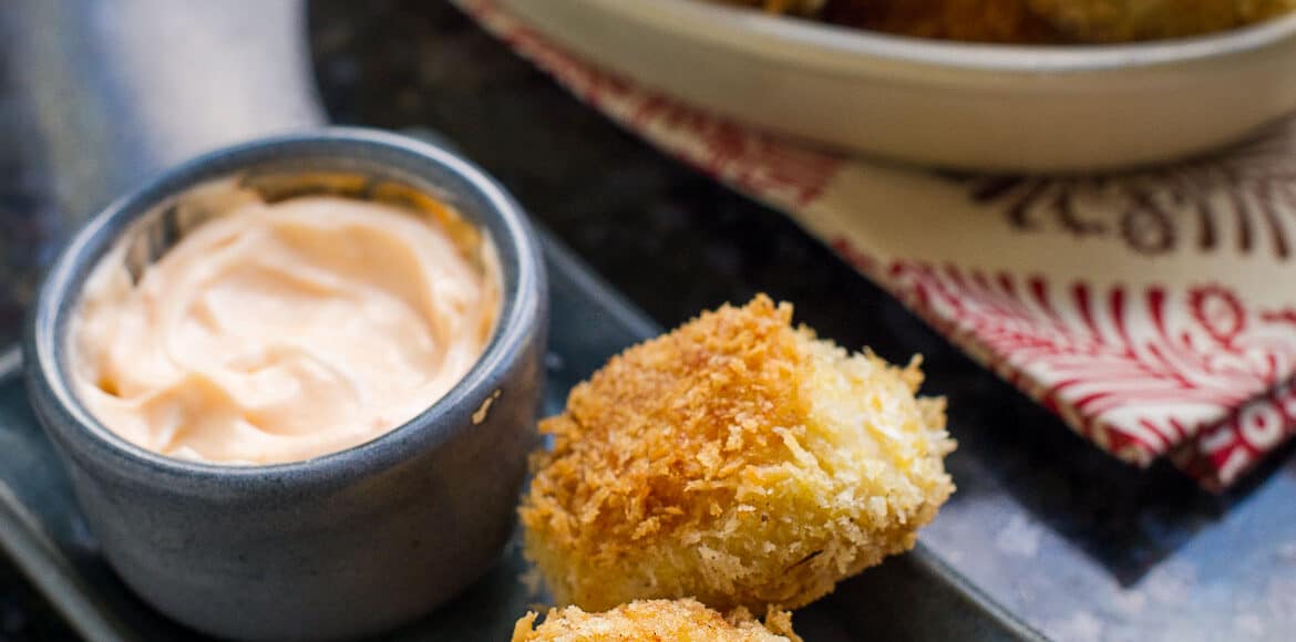 Shrimp and Potato Croquettes on a grey plate with a bowl of Sriracha Mayo.