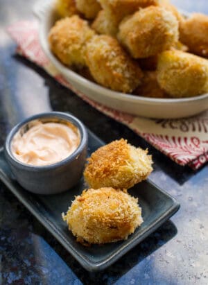 Shrimp and Potato Croquettes on a grey plate with a bowl of Sriracha Mayo.
