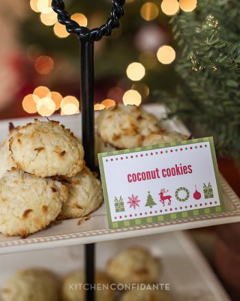 A decorative tiered stand full of cokies. A red and green sign says "coconut cookies".