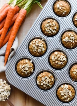 Carrot Oat Muffins in a baking pan with fresh carrots