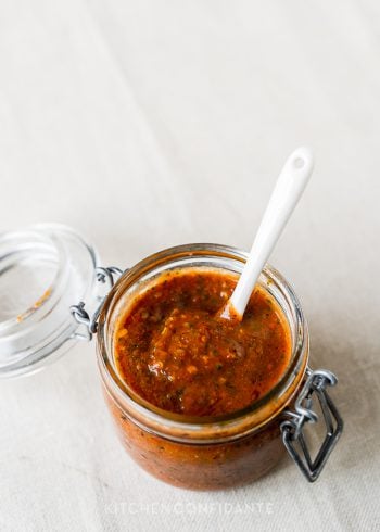 An open jar filled with homemade tomato harissa.