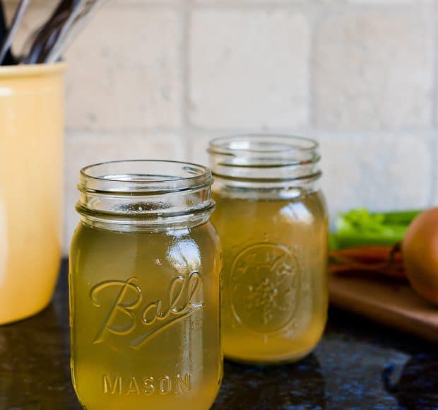 Two mason jars filled with homemade chicken stock.