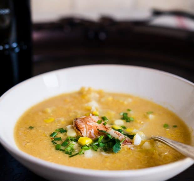 A white bowl filled with crab and corn chowder.