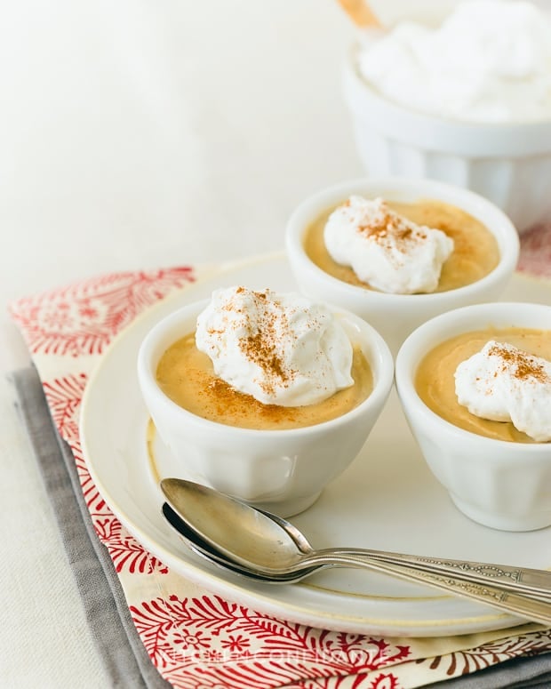 Cognac Butterscotch Pudding in small white ramekins topped with Cognac Whipped Cream.