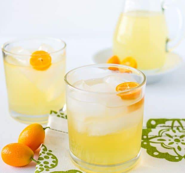 Kumquat cocktails in glasses with a garnish of fresh kumquats.