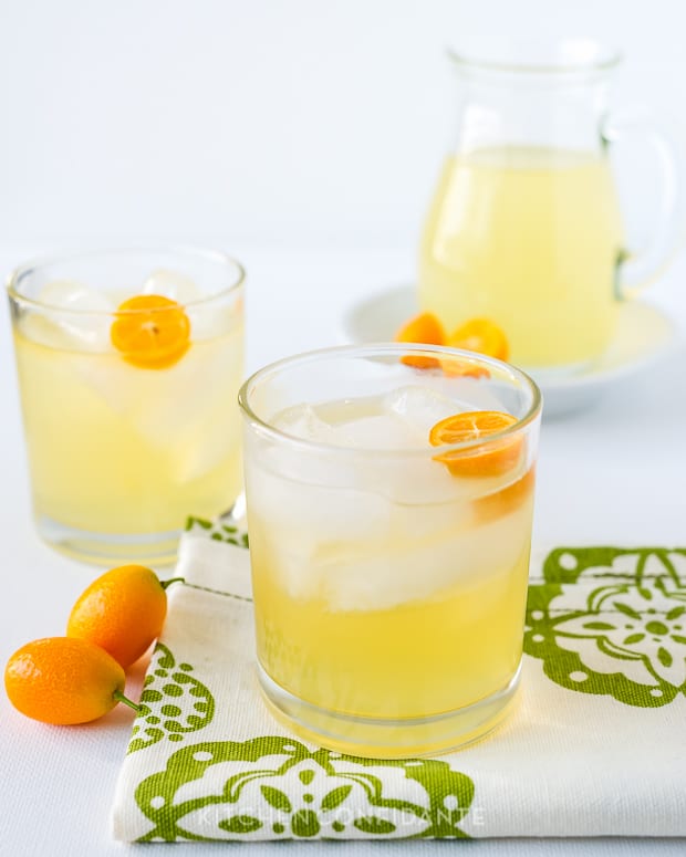 Kumquat cocktails in glasses with a garnish of fresh kumquats.
