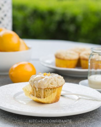 Meyer Lemon Ricotta Muffin with cupcake liner partially removed and served on a white plate.