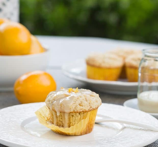 Meyer Lemon Ricotta Muffin with cupcake liner partially removed and served on a white plate.