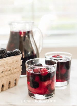 Glasses of Berry Sangria filled with bright red and blue summer berries.