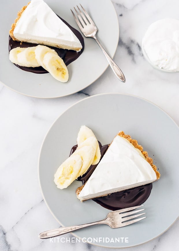 Slices of banana cream pie served with chocolate sauce and sliced bananas.