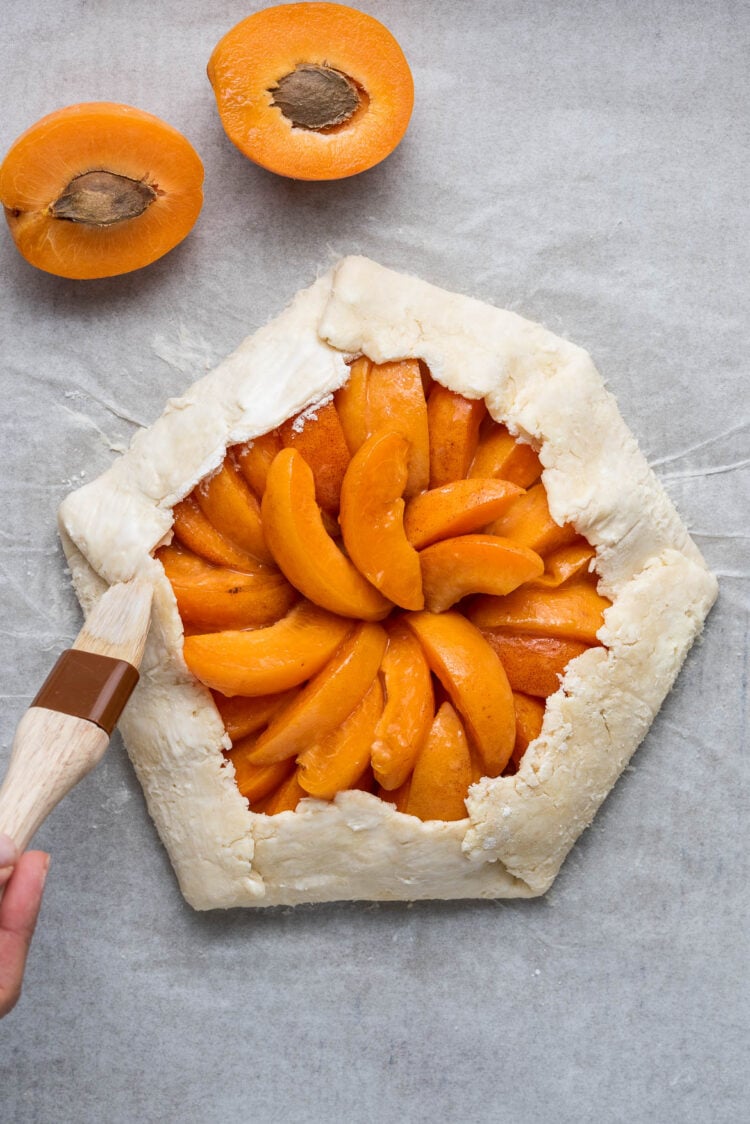 Brushing an Apricot Galette with a cream wash.