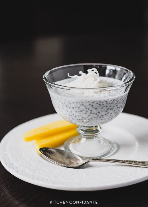 A serving glass on a white plate filled with Coconut Chia Pudding.