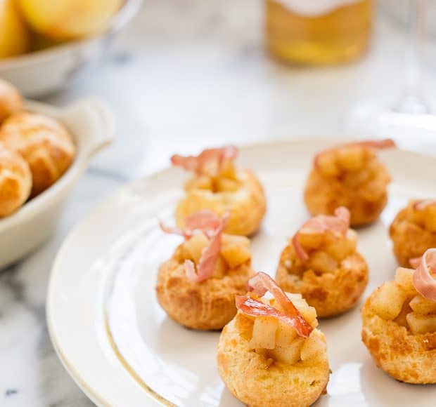 Apple Cheddar Gougères with Crispy Prosciutto arranged on a white serving plate.